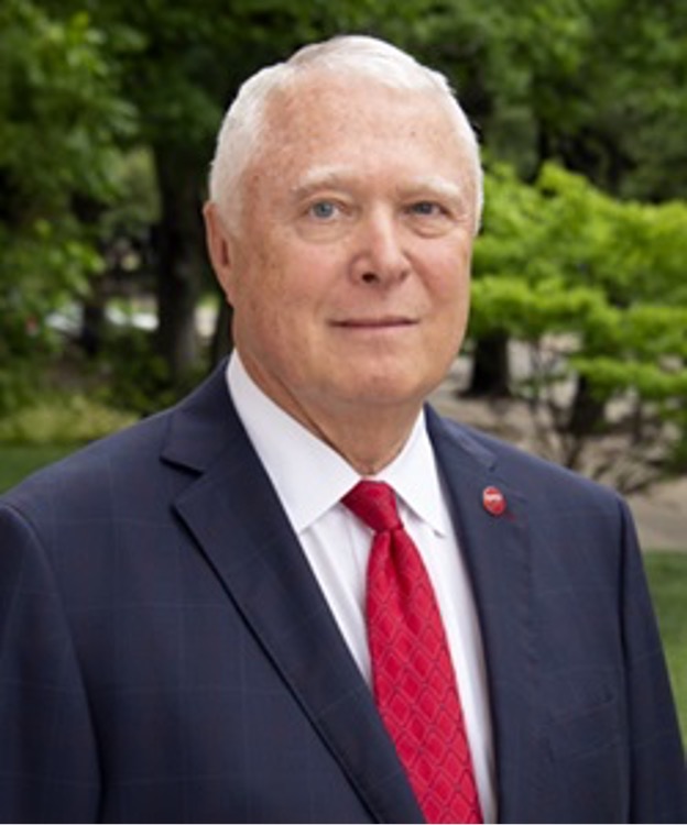 Paul J. Ward in a dark suit with a red tie